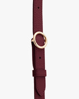 Thin belt with a round metal buckle.