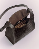 Bag with croc-embossed leather and open top showing zipper compartments inside.