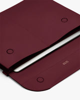 Open laptop sleeve with a tablet partially inserted and magnetic closures.