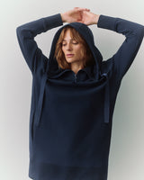 Person wearing a hoodie with arms raised above the head