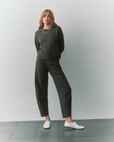 Person wearing a matching top and pants with white shoes standing on tiled floor