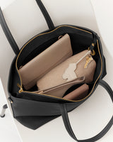 Open tote bag with a wallet, pouch, and keys inside.