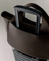 Luggage handle with a bag looped over it