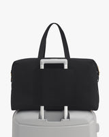 Travel bag on top of a suitcase with handle through strap
