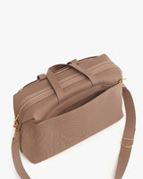 Travel bag with zippered compartments and a shoulder strap.