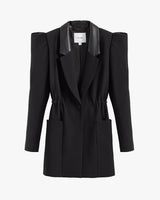 Blazer with exaggerated shoulder pads and lapels, buttoned front, and two pockets.