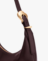 Close-up of a handbag strap with a buckle.