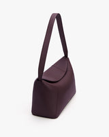 Shoulder bag with long strap and flap closure on white background.
