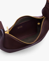 Open leather bag showing interior and zipper with brand name visible inside.