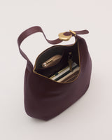 Open handbag with keys, phone, and notebook inside.