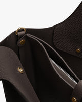 Open leather handbag with laptop sleeve attached via gold snap buttons