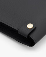 Close-up of a handbag corner with a metal clasp