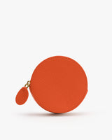 Round coin purse with zipper closure on white background.