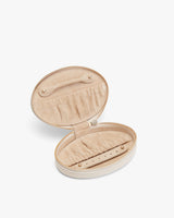 Open round jewelry case with pockets and a zipper closure.