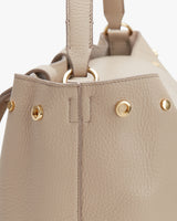 Close-up of a handbag with metallic details and stitching.