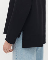 Close-up of a person wearing a coat and jeans.