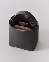Open handbag with items inside, including a wallet and a small pouch.