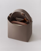 Open handbag with items inside, including a wallet and sunglasses.