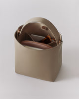 Open handbag with items inside, including a wallet and a small pouch.
