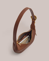 Handbag with a zipper open showing phone and wallet inside.