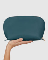 Hand holding a zipped pouch with brand name embossed
