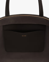 Close-up of a bag with a pocket featuring gold text detailing.