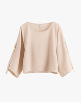 Loose-fitting, three quarter sleeve blouse on display.
