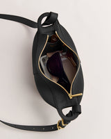 Open handbag with sunglasses and other items inside