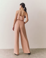Woman walking in sleeveless top and wide-leg pants.