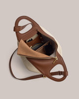 Open handbag with items inside including a wallet and sunglasses.