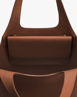 Open handbag with textured surface and pocket inside.