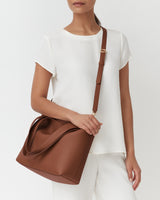 Person wearing a short-sleeve outfit with a crossbody bag
