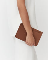 Person holding a leather pouch against their side