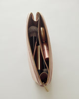 Zippered pouch containing makeup brushes and lipstick.
