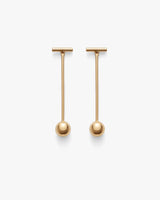 Two long drop earrings with round ends on a plain background.