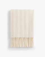 Fringed scarf folded neatly in a vertical view.