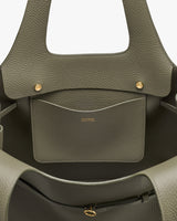 Open handbag interior with inner pocket and brand logo.