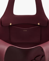 Open leather tote bag with inside pocket and two buttons.