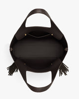 Open handbag with fringe on handles, viewed from above.