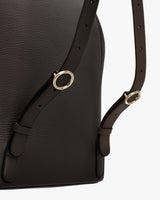 Close-up of a backpack with metal buckles and adjustable straps.