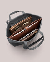 Top view of open tote bag with various contents inside