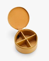 Round jewelry case with four compartments and a zipper lid.