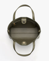 Open handbag with interior pocket and snap closure with two handles.
