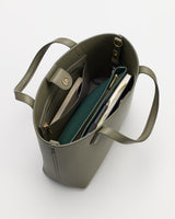 Open tote bag with multiple items inside seen from above