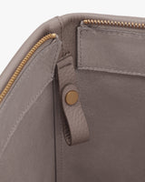 Close-up of the interior of a bag with zipper and button detail.