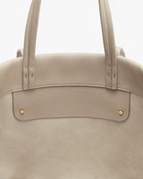 Tote bag with two handles and small gold studs.