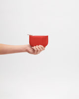 Hand holding a small zipped pouch.