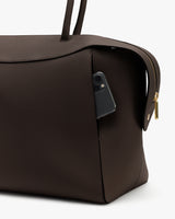 Travel bag with phone in side pocket and a zipper on the side.