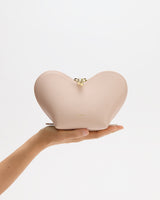 Heart-shaped bag held on a person's hand.