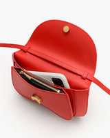 Open handbag with a phone and a zippered pouch inside.